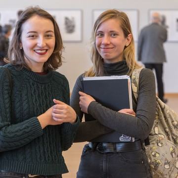 Dwie uśmiechnięte studentki podczas wernisażu